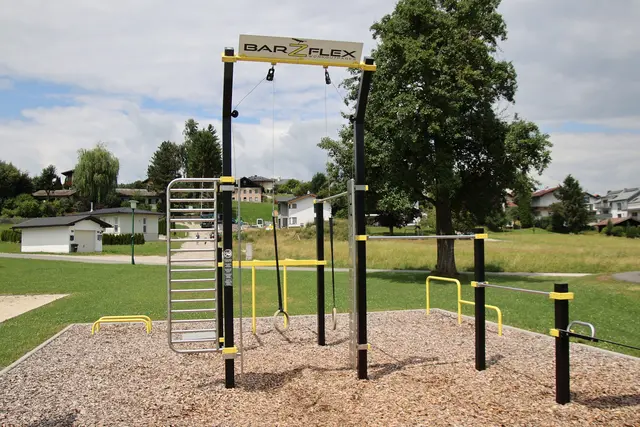 Neben dem Beachvolleyball-Platz finden sich Calisthenics-Geräte.