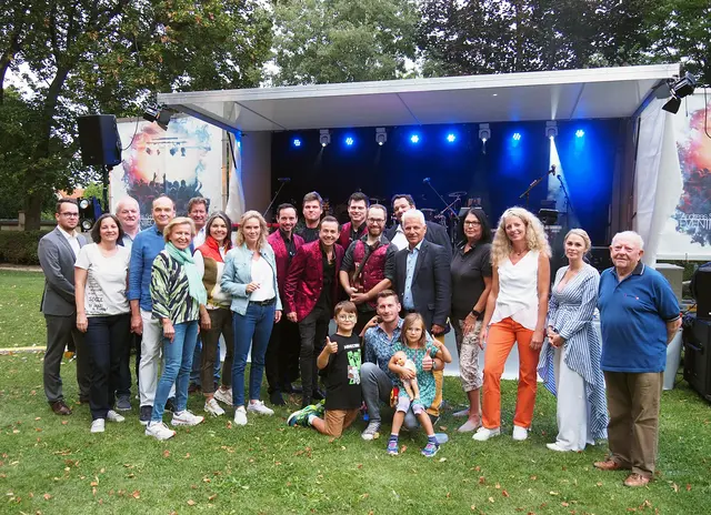 Kulturabteilungs-Leiterin Nadjeschda Morawec, Bürgermeister Johann Zeiner, Vizebürgermeisterin Michaela Haidvogel, Kulturgemeinderat Horst Kies sowie den Gemeinderäten Christian Klein, Bettina Sprosec, Peter Schinner, Hellfried Wunsch, Eva Morawetz, Leopold Salm-Reifferscheidt-Raitz, Lydia Bayer, Markus Waldner, Jürgen Tiefnig, Ingrid Bresich und Corinna Cernik beim Gruppenfoto mit der Band Stereoparty.