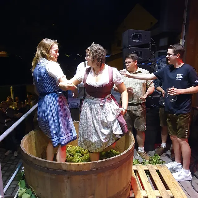 Die Weinhoheiten Laura und Tanja haben sichtlich Spass beim traditionellen Traubentreten | Foto: Eva Gabriel