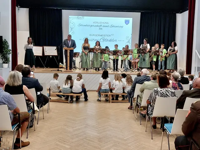 Alt-Bürgermeister und Ehrenbürger Gustav Glöckler bei seiner Dankesrede; re. Musikverein Wöllersdorf-Steinabrückl mit Kindern aus dem Jugendblasorchester