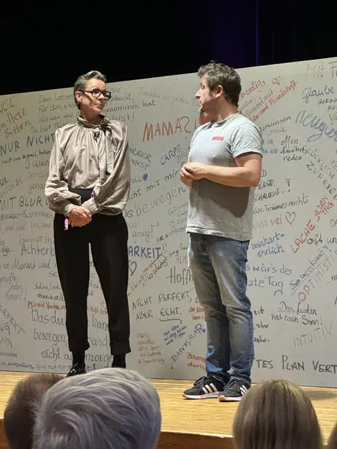Lukas Leiter und Karoline Riml führen in das Stück ein, das Erfahrungen von Krebspatient*innen offen und ungeschönt zeigt.
