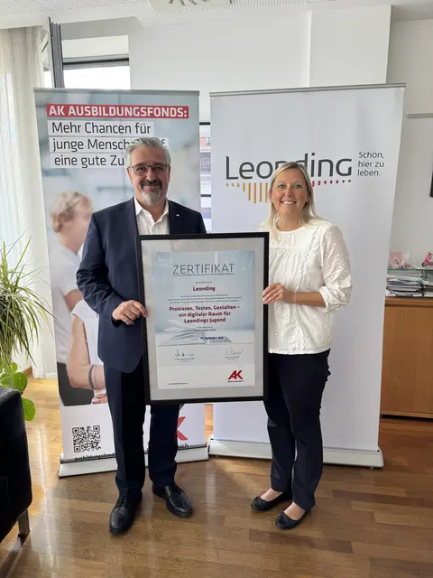 AK-Präsident Andreas Stangl übergibt das Zertifikat an Bürgermeisterin Sabine Naderer-Jelinek. | Foto: Stadtarchiv Leonding