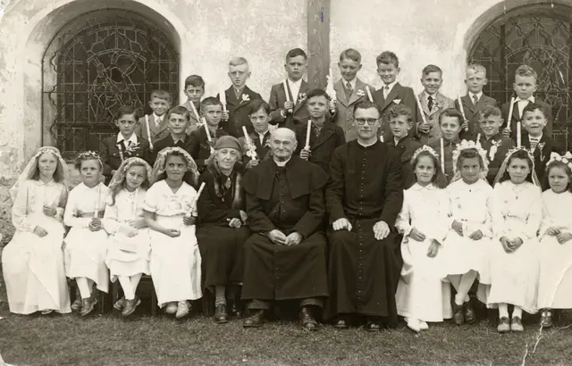Erstkommunion in den 1950er Jahren in St. Stefan. Bildmitte: Pfarrer Anton Pelnar, der am 17. Jan. 1899 nach St. Stefan kam und hier 63 Jahre wirkte. Links: Volksschuldirektorin Justine Muhr, rechts: Kaplan Anton Gorsek. | Foto: Fam. Hans Ferlitsch
