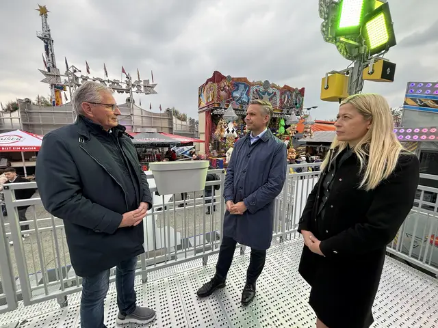 Wirtschaftsminister Wolfgang Hattmannsdorfer (Bildmitte) und Stadträtin Doris Lang-Mayerhofer im Gespräch mit Schausteller Peter Kammerhofer.  | Foto: MeinBezirk Linz