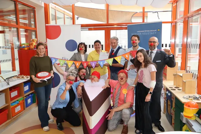 1. Reihe: Alexandra Klug (regionale Programmleitung NÖ – Rote Nasen); Dipl. KH-BW DGKP Christa Grosz, MBA, MBA (Pflegedirektorin UKWN); Clown Harald, Clownin Zitronella (Torte); Clown Norbert und Patientin Sarah. 2. Reihe: DGKP Lenuta Drago, BScN (Bereichsleitung Pflege UKWN); DKKP Siegrid Jusinger (Stationsleitung UKWN); Martin Kotal  künstlicher Leiter Österreich – Rote Nasen); Prim. Dr. Wolfgang Schebesta (Abteilungsvorstand UKWN) und Prof. Dr. Ojan Assadian, MSc, DTMH
(Ärztlicher Direktor UKWN). | Foto: Universitätsklinikum Wiener Neustadt