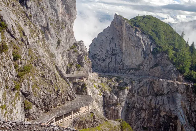 Bild # 2874: Blick hinab auf die Steinschlag- Galerien des Zugangs zur Eingangshöhle. Am unteren Ende ist das Stollenportal zu erkennen. Hier werden die Besucher über einen Stollen sicher vor Steinschlag umgeleitet. Die sichtbare Fortsetzung des Weges ist gesperrt und rechts kann man das Stollenportal erkennen, wo man wieder auf sichern Weg gelangen kann. | Foto: © by Ing. Günter Kramarcsik