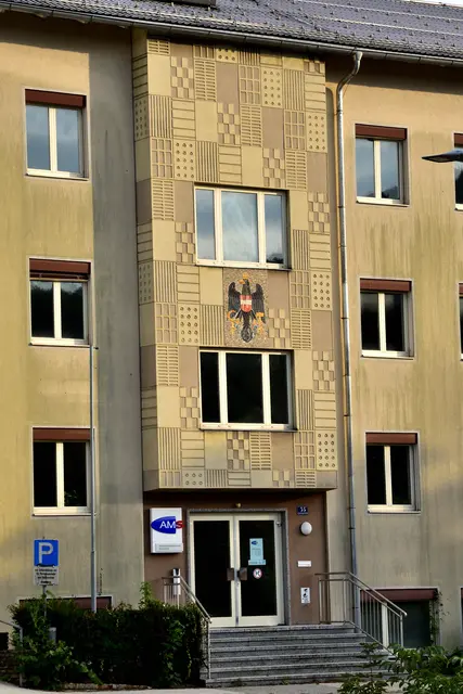 Künstlerische Ausschmückung der Fassade (Sgraffito und Mosaik) über dem Eingangsbereich durch den akademischen Maler Leopold Schmid (1901-1989). | Foto: Hans-Peter Kriener