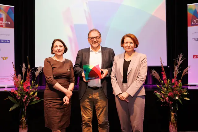 Reinhard Heiserer, Mitgründer und Geschäftsführer der österreichischen Entwicklungsorganisation Jugend Eine Welt, wurde bei den Fundraising Awards des Fundraising Verband Österreich als „Fundraiser des Jahres 2025" ausgezeichnet. Im Bild: Reinhard Heiserer (Mitte), Laudatorin Sophie Lauringer (links) und Ruth Williams, Geschäftsführerin Fundraising Verband Österreich. | Foto: Sima Prodinger