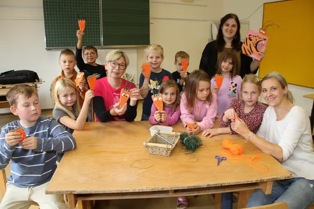 Die Schülerinnen und Schüler zeigen Bezirksbäuerin Angelika Wechtitsch (Mitte) stolz die selbst gemachten Karotten-Lesezeichen. | Foto: Josef Fürbass