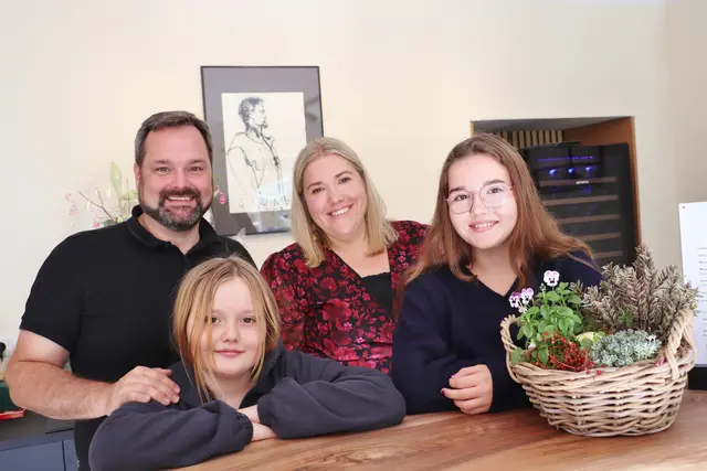Georg und Anna Thünauer mit ihren Töchtern Helena und Isabella an der Nussholztheke ihrer Vinothek in Fernitz-Mellach. | Foto: Edith Ertl
