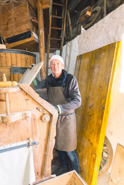 Obmann Franz Heidegger beim Mehl mahlen in der Mühle. | Foto: Pernsteiner