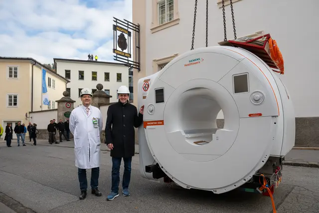 Gottfried Schaffler, Primar der Radiologie und Nuklearmedizin im Krankenhaus der Barmherzigen Brüder Salzburg und Direktor Arno Buchacher mit dem neuen, über vier Tonnen schweren MRT-Gerät, das voraussichtlich ab dem Frühjahr 2026 zum Einsatz kommt.  | Foto: Neumayr/Moser