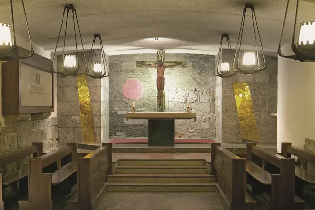 Die Anbetungskapelle in der Krypta des Salzburger Doms. Die Rückwand aus Naturstein-Mosaik wurde von Bildauer Karl Knappe aus München gestaltet, darauf sind zwei goldene Strahlen und die Ostermorgensonne zur Auferstehung Jesus Christus zu sehen. Das romanische Kreuz wurde in Seekirchen gefertigt. | Foto: Dommuseum Salzburg/J. Kral