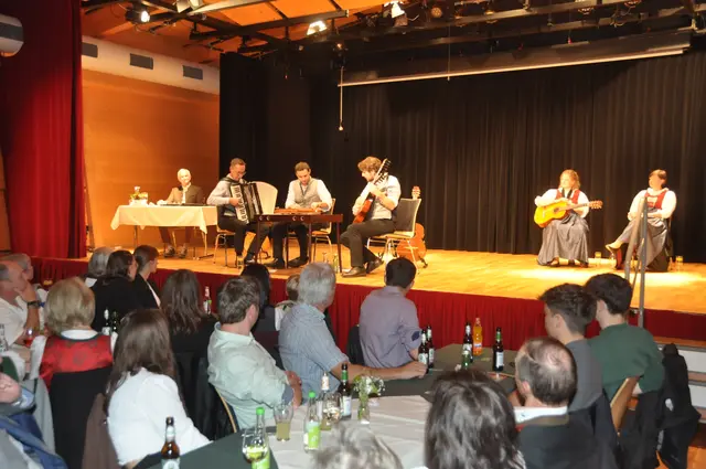 Sprecher Rudi Krausse, die Leukentaler Stubenmusik (Martin Hechenblaikner, Wolfgang Schipflinger, Maximilian Hechenblaikner) und die Huber-Dirndln im voll besetzten Dorfsaal