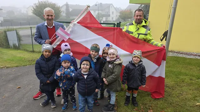 Bürgermeister und Kinder hissen die Rot-Weiß-Rot Fahne im Kindergarten. | Foto: Gemeinde Weinburg