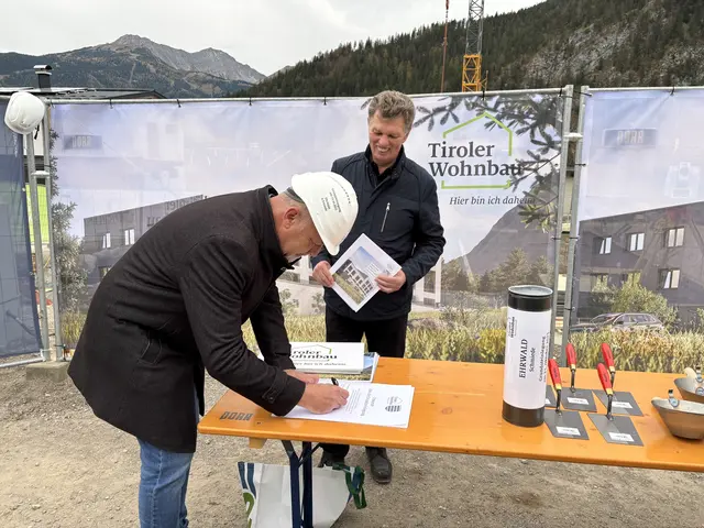 Bgm. Markus Köck verewigte sich auf einem Dokument, welches an die Bauzeit erinnert. Im Hintergrund Walter Soier von der Tiroler Wohnbau. | Foto: MeinBezirk/Günther Reichel