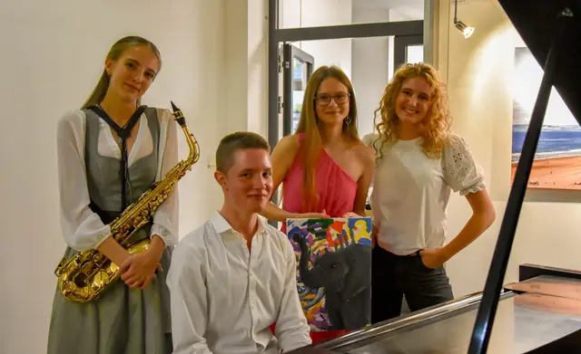 Foto-Künstlerin Laura Watzl (3.v.l.)  freut sich mit den Musikern Sarah Brodinger und Marius Szitovszky und Moderatorin Sarah Taxer über die gelungene Vernissage.                                         Foto: Emina Peter 