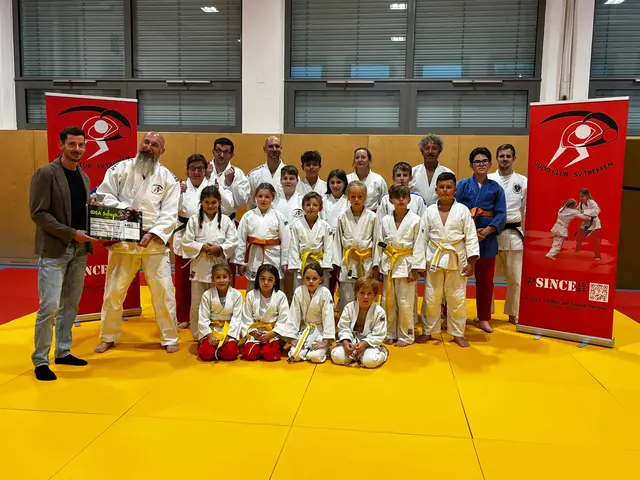 (links) Werner Obrist, Außendienstmitarbeiter im Exklusivvertrieb bei Helvetia über-reicht den Scheck Markus Mayer, Obmann des Judoclubs SV Treffen und (rechts hinten) Philipp Hinteregger, sportlicher Leiter, mit den Kindern &amp; Erwachsenen des Vereins | Foto: Helvetia