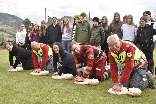 Im Bild v.l.: Martin Pfanner (Kuratorium für Verkehrssicherheit), Bert Neuhofer (Vizepräsident Rotes Kreuz Salzburg), Landesrätin Daniela Gutschi, Notarzt Bernhard Schnöll und Herbert Wieser (Bezirksgeschäftsführer Rotes Kreuz Lungau) sowie Schülerinnen und Schüler der Mittelschule Sankt Michael. | Foto: Land Salzburg/Franz Neumayr