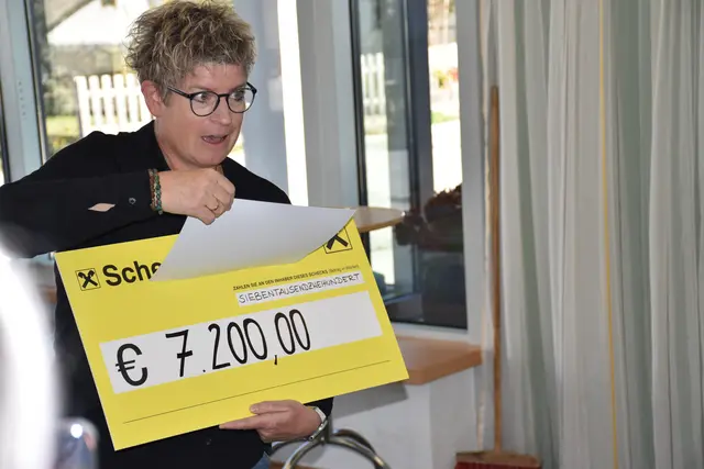 Friedrun Schreder enthüllt den Scheck mit 7.200,- Euro.  | Foto: Haun