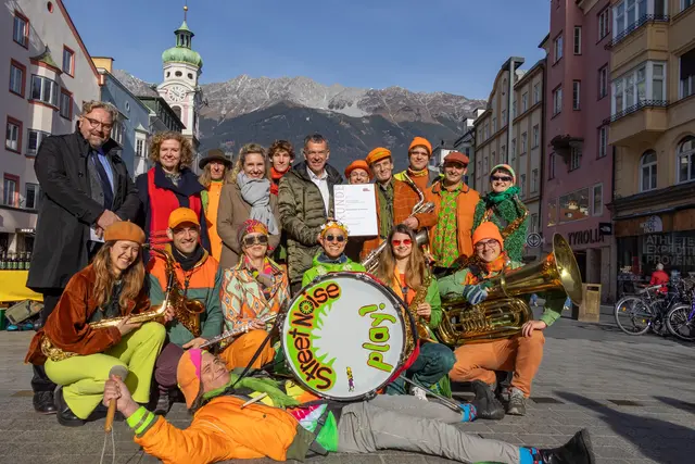 Bunt und laut: Der Arthur-Haidl-Preis der Stadt Innsbruck 2025 ging an das Innsbrucker StreetNoise Orchestra. Vizebürgermeister Georg Willi (Bildmitte), Magistratsdirektorin Gabriele Herlitschka (2. v. l.), Kulturamtsleiterin Isabelle Brandauer (4. v. l.) und Dirk Rupnow (Vizerektor für Personal an der Universität Innsbruck, li.) freuen sich mit dem ehrenamtlichen Musikverein.  | Foto: © M. Freinhofer