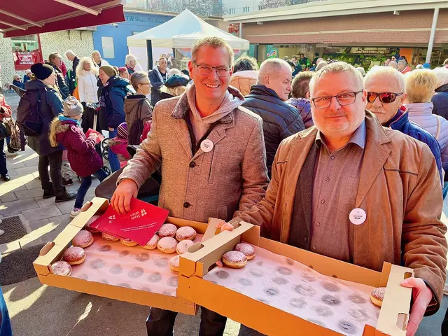 Bezirksvorsteher Georg Papai (SPÖ, l.) und Marktvorsteher Andreas Kutheil (r.) verteilen zum Faschingsstart Krapfen am Schlingermarkt. | Foto: Marktamt Wien