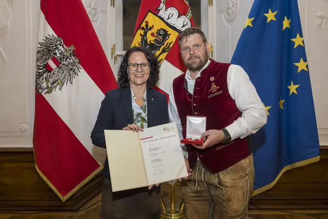Landesrätin Daniela Gutschi überreicht Vizebürgermeister a.D. Michael Macheiner aus Muhr das Verdienstzeichen des Landes Salzburg. Stadt Salzburg, 11.11.2025  | Foto: Land Salzburg/Neumayr/Christian Leopold