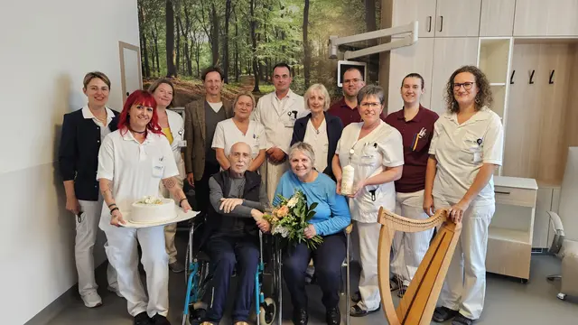 Leitende Diätologin Andrea Waser, DGKP Nina Kreimer, OÄ Dr. Elisabeth Mock (Leitung Palliativstation), Standesbeamter Friedrich Bühringer, Stationsleitung DGKP Manuela Supanschitz, Prim. Univ. Prof. Dr. Armin Gerger (Leiter Innere Medizin 2), DGKP Anna Hübl, DGKP Florian Rumpl, DGKP Inge Enengel, DGKP Julia Kronberger, Musiktherapeutin Barbara Riepert mit dem frischvermählten Ehepaar Reinhard Tauscher und Carmen Antonijevic. | Foto: Landesklinikum Amstetten