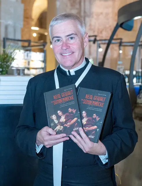 Augustiner-Chorherr Elias Carr mit seinem Buch „Neid, Gewalt und Sündenböcke“ | Foto: Stift Klosterneuburg/Walter Hanzmann