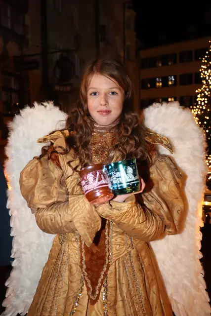 Engel Lara präsentiert die neuen Glühweintassen des Innsbrucker Christkindlmarktes. | Foto: Kendlbacher