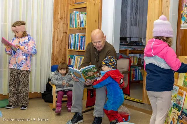 Der kleine Marten will genauer die Bilder des Buches betrachten, das Thomas Schwab ließt. | Foto: www.cine-motion.at / Ivanek