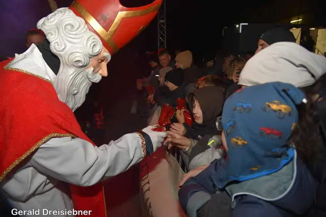 Der Nikolo mit der Holzmaske überreichte den kleinen Kinder Sackerl.  | Foto: Gerald Dreisieber