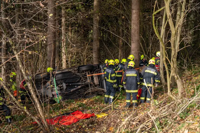 Ein Auto stürzte eine Böschung hinab und blieb seitlich an einem Baum liegen – die Lenkerin wurde von der Feuerwehr unverletzt befreit. | Foto: TEAM FOTOKERSCHI / MARTIN SCHARINGER