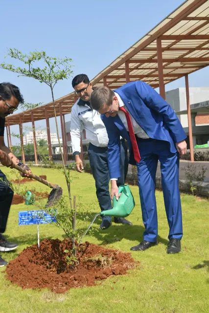 Das 2023 nach nur 18 Monaten Bauzeit eröffnete Werk in Pune setzt für Indien Maßstäbe in Sachen Nachhaltigkeit: Es produziert mehr Strom und Wasser, als verbraucht wird. Und wo vor dem Bau nur ein Baum stand, sind es jetzt 12.000 - seit dem Besuch der oberösterreichischen Wirtschaftsdelegation 12.001. Denn Landesrat Markus Achleitner durfte seinen eigenen Baum mit Widmungs-Schild einsetzen und auch gleich gießen.  | Foto: Bajaj