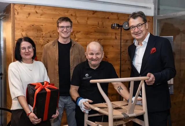 Die glücklichen Gewinner des Abends: Romana Brugger (Baobab-Duftkerze) und Bernhard Huber (Wishbone Chair) mit Flechter Benni Larson und Hausherr Martin Wetscher
