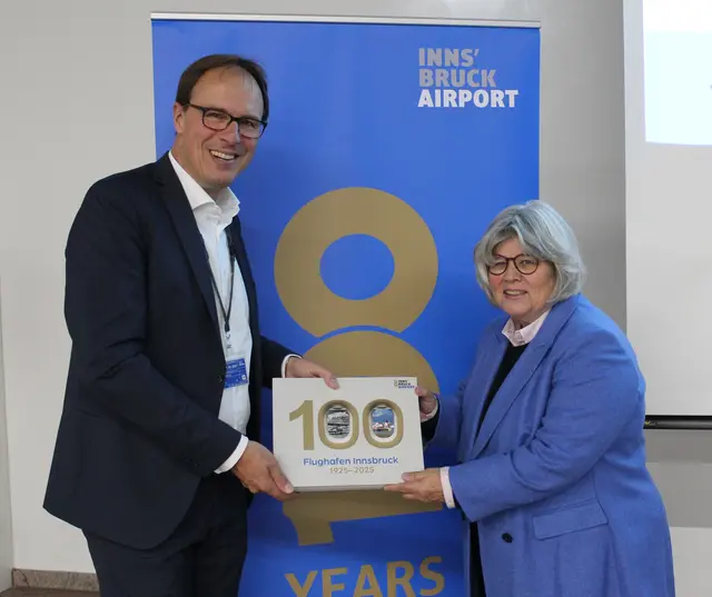 Flughafengeschäftsführer Marco Pernetta (links) und Luftfahrthistorikerin Tanja Chraust präsentieren den neuen Bildband ‚100 Jahre Flughafen 1925–2025‘. | Foto: Flughafen Innsbruck