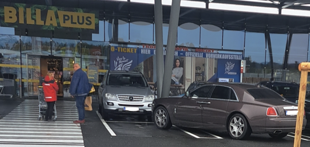 Ein Auto stand quer über zwei Parkplätze am Billa Plus, während sich der Eigentümer gemütlich am Zebrastreifen daneben unterhielt. | Foto: Aimée Simek 