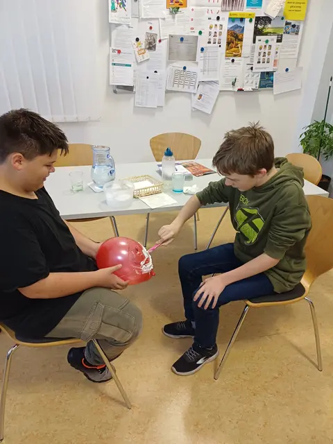 Nachdem sich kein Freiwilliger gemeldet hat, wurde an einem Luftballon das Rasieren geübt. | Foto: Caritas Recycling Vitis
