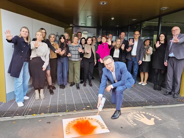 Geschäftsführer sprayt orange Hände auf Gehtsteig, dahinter stehen MitarbeiterInnen mit ausgestreckter Hand als Stop-Zeichen gegen GewaltDie Oberösterreichische Gesundheitsholding und ihre Kliniken machen auch heuer wieder im Rahmen von „Orange the World“ auf das Thema Gewalt gegen Frauen aufmerksam. | Foto: OÖG