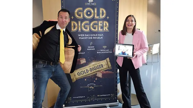 TV-Moderator Oliver Feicht und Ksenia Petrova  präsentieren den neuen Proteinriegel „Gold Digger". Ab 10. Dezember 2025 ist dieser bei John Harris Fitness, Billa-Kaufleuten, Sun Company und ARBÖ Wien erhältlich. | Foto: Feicht