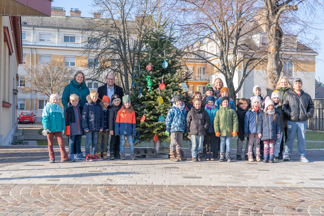 Bürgermeister Markus Mentl-Weigl mit der Volkschulklasse die mit ihm den Christbaum am Marktplatz geschmückt hat. | Foto: Stadtgemeinde Deutsch-Wagram