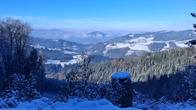 ....in die schneebedeckte Landschaft
Mittig sieht man über dem ATTERSEE zum
 BUCHBERG, den ein schönes  " WOLKEN-BAND" umgibt.