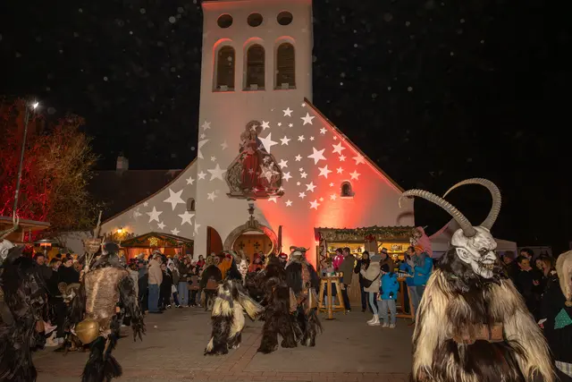 Die "Schwadorfer Höllenteufel"  vor dem Kirchenplatz umringt von neugierigen Besuchern. | Foto: cine-motion.at / R. Ivanek
