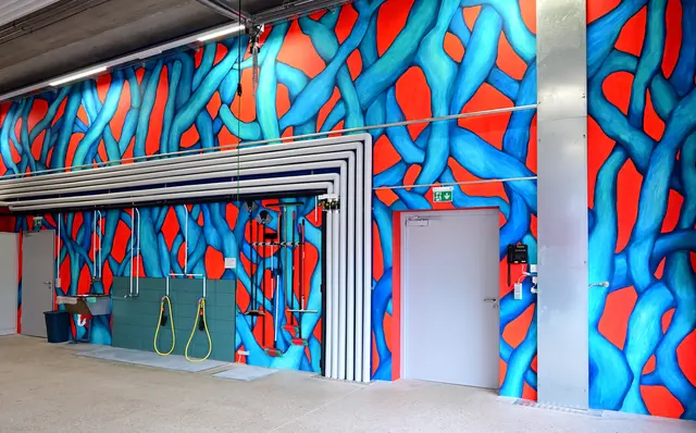 Kunst am Bau trifft auf Gebäudetechnik in der 2024 errichteten Fahrzeughalle der Feuerwehr Naarn: "Das Bild ist so kräftig, dass diese Leitungen kein Problem sind", so Malerin Anna Maria Brandstätter. | Foto: Hans-Peter Kriener