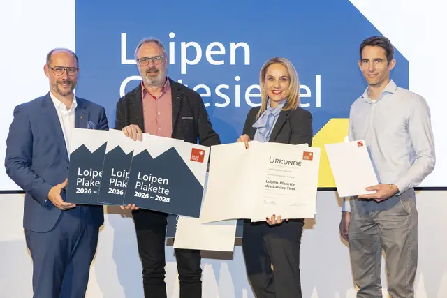 Landesrat Mario Gerber (links) gemeinsam mit Reinhard Klier, Sprecher der Tiroler Seilbahnwirtschaft (rechts), und Simone Larcher, Vorständin der Abteilung Sport des Landes Tirol (zweite von rechts), bei der Verleihung an die Loipengebiete Lavant, Matreier Tauernhaus und Innervillgraten. | Foto: WKT/Die Fotografen