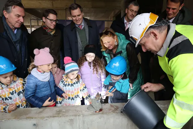 Die Kindergartenkinder durften die Zeitkapsel unter Anleitung selbst einmauern. Im Hintergrund v. l.: Martin Czerny von Czerny Immobilien, Stadtrat Clemens Ableidinger (NEOS), Bürgermeister Christoph Kaufmann (ÖVP), Vizebürgermeisterin Bildungsstadträtin Maria T. Eder (ÖVP), sowie Stadtrat Roland Honeder (ÖVP). | Foto: Stadt Klosterneuburg/Lutz