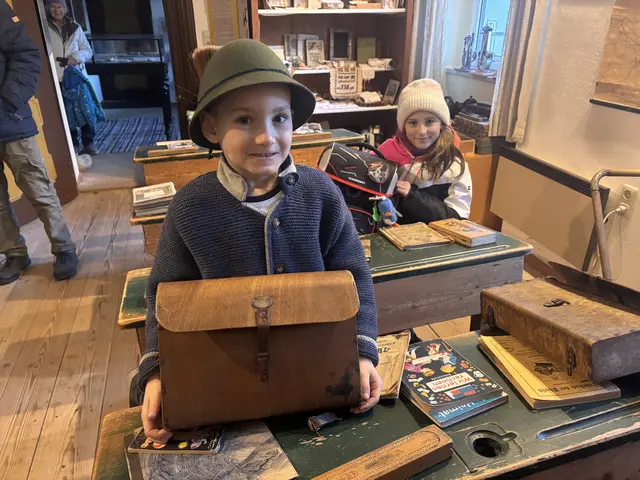 Florian präsentiert einen alten Ranzen aus Holz, seine Schwester Marlies hat eine zeitgemäße Schultasche mitgebracht. | Foto: Weymayer