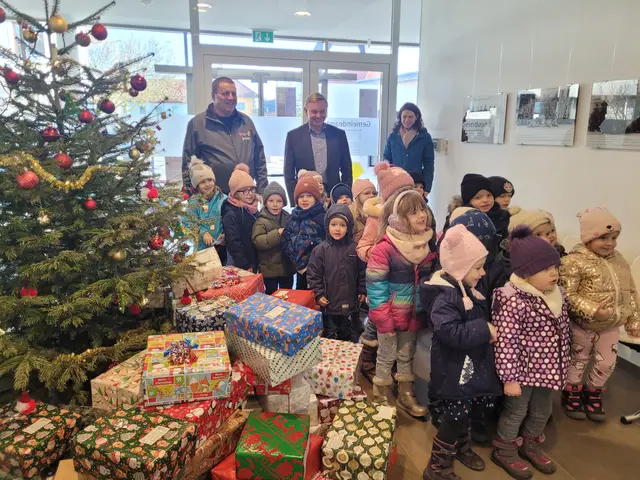 Kindergartenkinder beteiligten sich an der Aktion Christkind in der Schuhschachtel. Sie halfen Helmut Atzlinger (hinten links) und Bürgermeister Karl Schneckenleitner (hinten Mitte) beim Einpacken in das Transportauto.