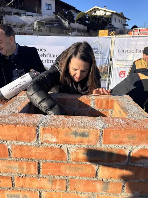 LR Astrid Mair bettete die Zeitkapsel fachgerecht in den Mörtel ein. | Foto: Johanna Bamberger