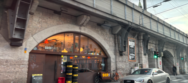 Die Brauerei besteht aus dem Braukeller mit Lagertanks (Haus Nr. 24) und dem Suhaus &amp; Taproom (Haus Nr. 25, hier im Bild), die durch die Dreiheiligenstraße samt Ampelregelung zur "Bierkreuzung" bzw. Ing.-Etzel-Straße getrennt ist. So braucht es für die Verbindung der Kessel eine Pipeline über die Viaduktbögen.
